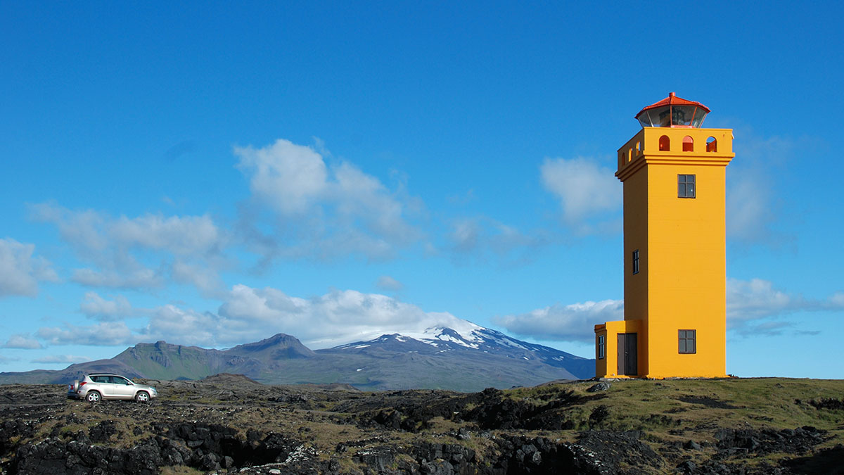 Leuchtturm vor dem Vulkan Snaefellsjökull, bei Jules Vernes "Reise zum Mittelpunkt der Erde" der Einstieg in die Unterwelt
